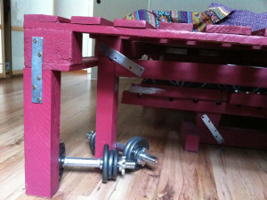 King size bed made of pallets and timber beams, foot detail